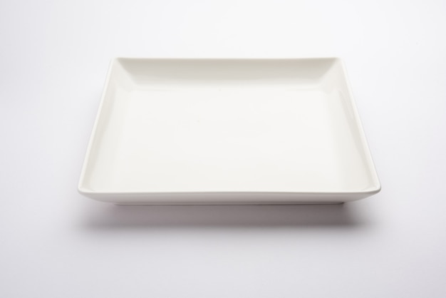 Piatto quadrato in ceramica bianco vuoto isolato su sfondo bianco
