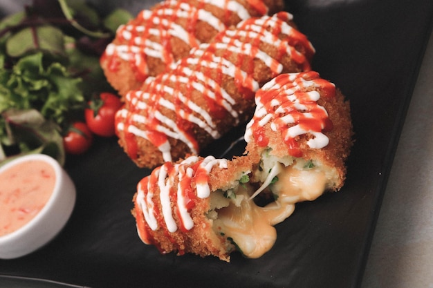 Piatto snack delizioso, patatine fritte, anelli di cipolla, involtini primavera o salsicce sul tavolo