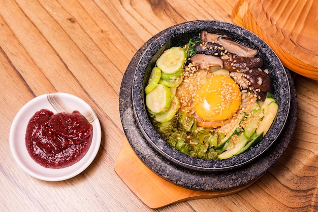 Piatto tradizionale coreano bibimbap riso misto con verdure Include manzo e uovo fritto