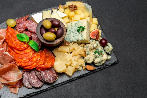 Piatto tradizionale di carne e formaggio - parmigiano, carne, salsiccia e olive