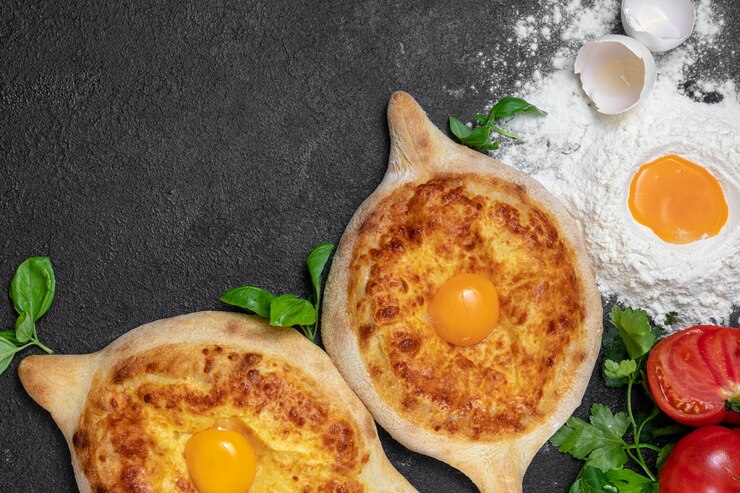 Piatto tradizionale georgiano Khachapuri adjarian su sfondo scuro decorato pasticceria fresca calda