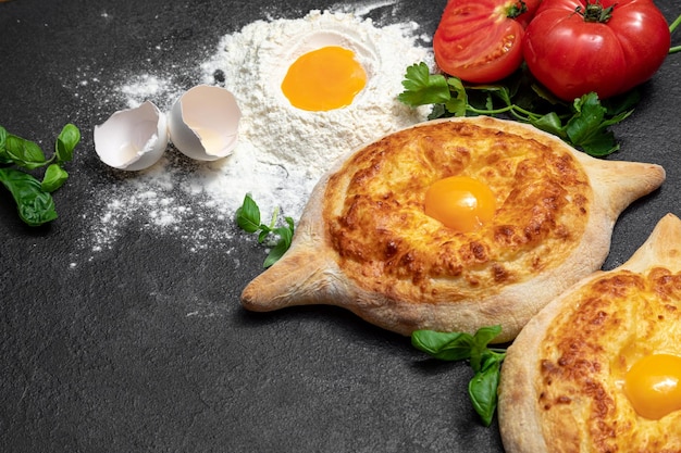 Piatto tradizionale georgiano Khachapuri adjarian su sfondo scuro decorato pasticceria fresca calda