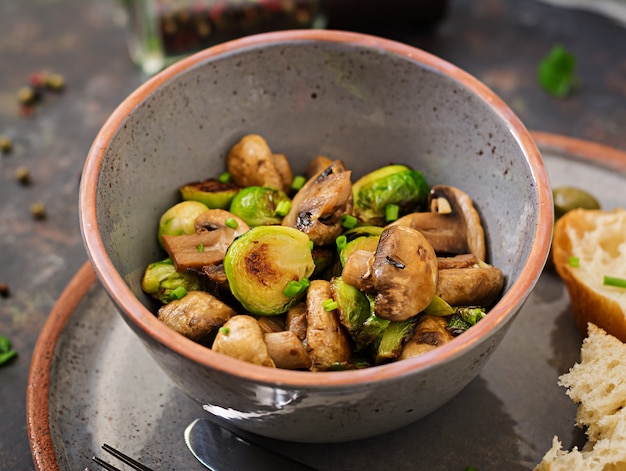 Piatto vegano. Funghi al forno con cavoletti di Bruxelles ed erbe aromatiche. Nutrizione appropriata.