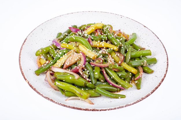 Piatto vegetariano a base di fagiolini con cipolle rosse sottaceto e semi di sesamo. Foto dello studio.