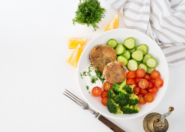 Piatto vegetariano di polpette di patate con erbe e verdure su un piatto