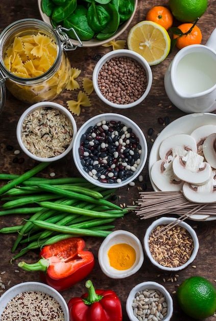 Piatto vegetariano sano cibo set cereali verdure frutta pasta semi su uno sfondo di legno marrone