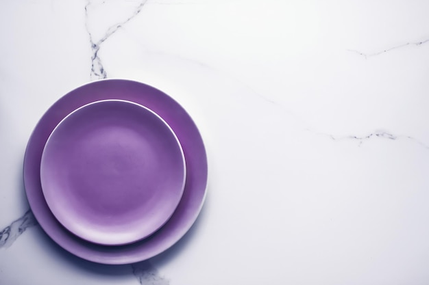 Piatto vuoto viola su sfondo tavolo in marmo decorazioni per la tavola per colazione, pranzo e cena per ristorante, menu di marca, ricetta, vacanza di lusso, design flatlay