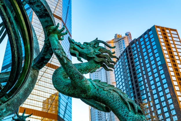 Piazza del centro città di Qingdao Drago cinese scultura e grattacielo