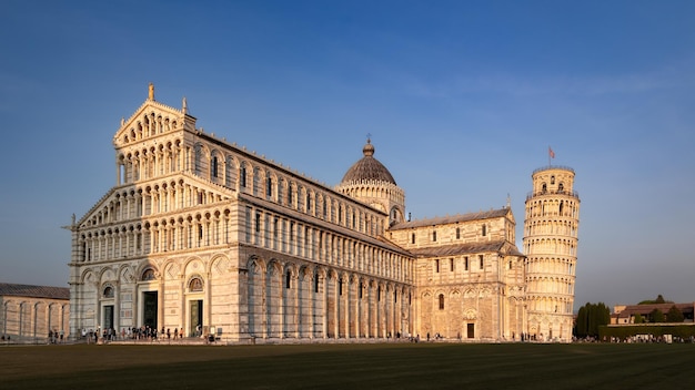 Piazza del Duomo con la Torre Pendente e la Cattedrale di Pisa con folla di turisti al tramonto Pisa Italia