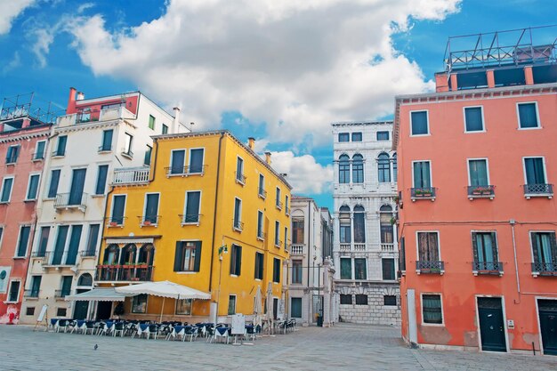 Piazza veneziana con edificio colorato sotto un cielo nuvoloso