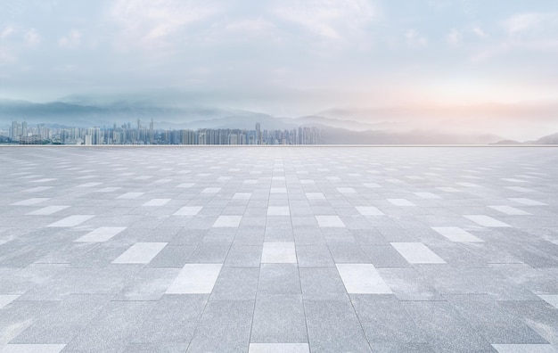 Piazza vuota con pavimento in mattoni con vista panoramica sullo skyline della città e sull'architettura