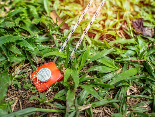 Picchetto da tenda rosso che tiene una corda