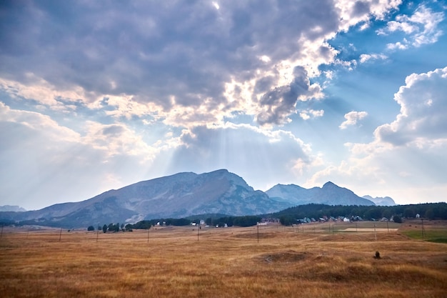 Picchi di montagna e raggi di sole dietro le nuvole nel cielo