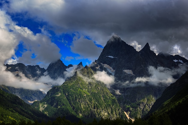 Picco della montagna con ghiacciai sullo sfondo di nuvole e cielo. Cresta del Caucaso, Russia.