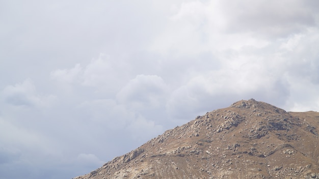 Picco di montagna con alcune nuvole e cielo blu chiaro