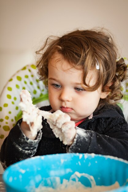 Piccola bambina che gioca con la pasta