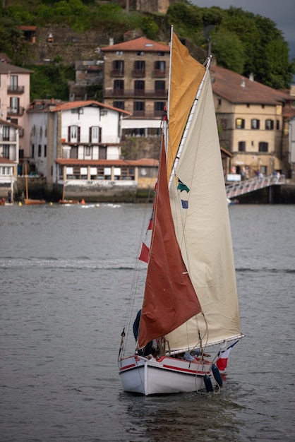 Piccola barca a vela che naviga nel porto