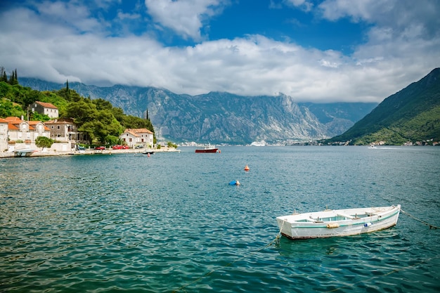 Piccola barca bianca che galleggia nel mare vicino al villaggio di Perast nella baia di Boka Kotor Montenegro