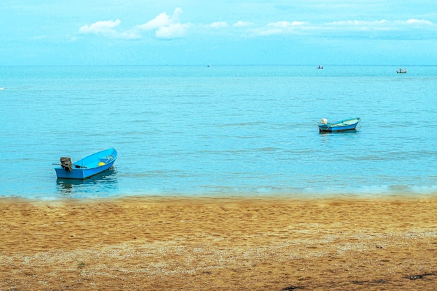 Piccola barca da pesca galleggiante nel mare blu con cielo blu, Thailandia Barca da pesca o pescatore in barca o nave su Sam Roi Yod bech Prachuap Khiri Khan Thailandia con cielo blu e nuvole e mare blu.