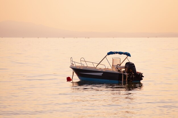 Piccola barca sul mare al tramonto