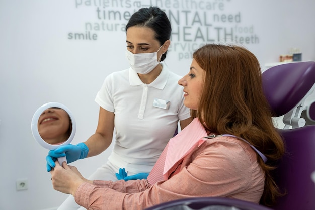 Piccola bella paziente seduta in odontoiatria con dottoressa