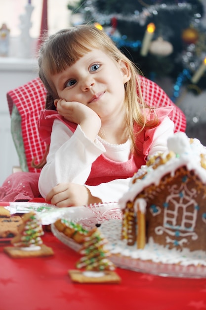 Piccola bella ragazza con una casa di pasta di pan di zenzero