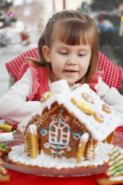 Piccola bella ragazza con una casa di pasta di pan di zenzero