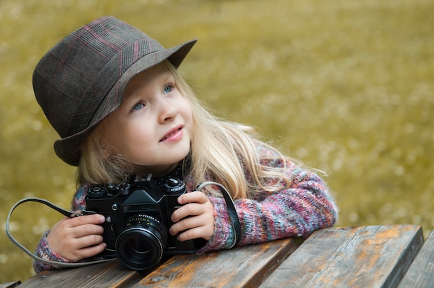 Piccola bella ragazza con una macchina fotografica