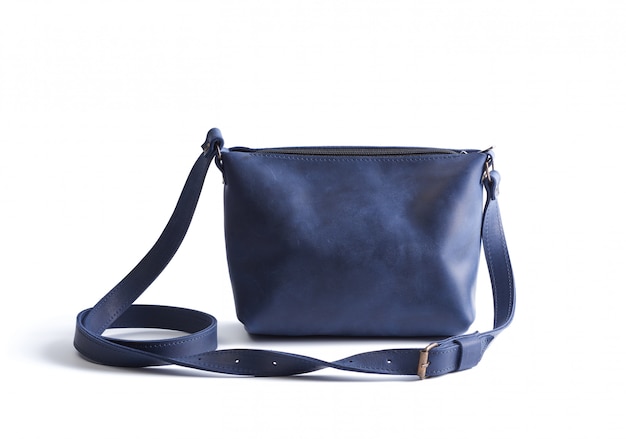 Piccola borsa di cuoio blu con una maniglia lunga isolata su una priorità bassa bianca
