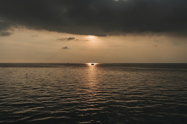 Piccola capanna di pescatori in mezzo al tramonto e al mare