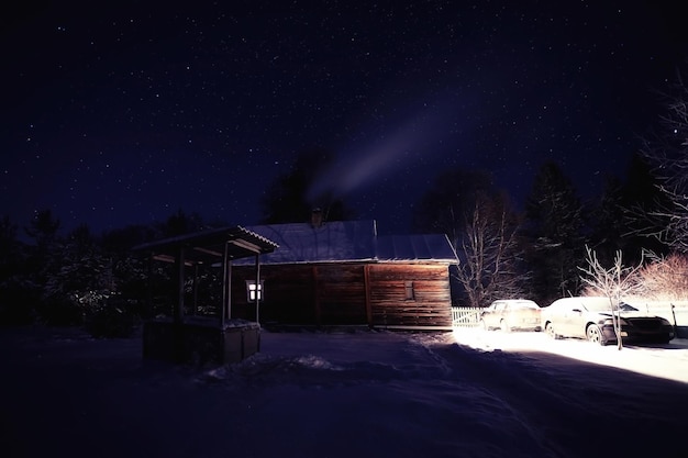 Piccola casa del villaggio del paesaggio di notte di inverno