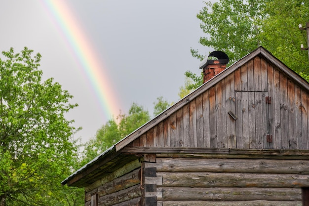 Piccola casa di campagna in una sera d'estate Arcobaleno sopra la casa Bel tramonto Fiori in giardino Russia