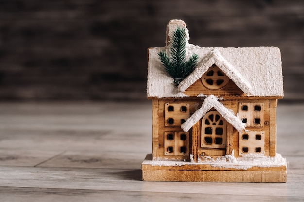 Piccola casa di Natale innevata sul pavimento della casa.