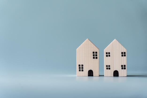 Piccola casa in legno su sfondo azzurro per il concetto di edificio residenziale e immobiliare
