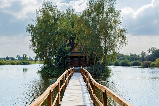 Piccola casa sull'isola Paesaggio con ponte per la casa sul lago Vecchio legno