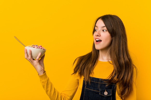 Piccola donna che tiene una ciotola di cereali