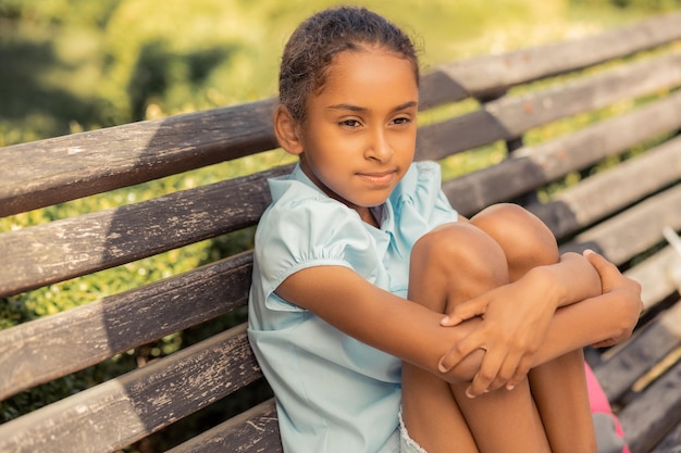 Piccola donna sognante che pensa ai suoi compagni di scuola