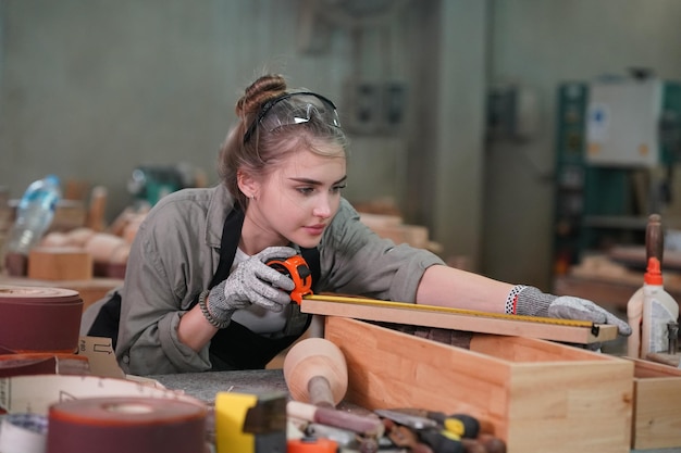 Piccola impresa di una giovane donna Attraente giovane donna falegname designer lavora in officina