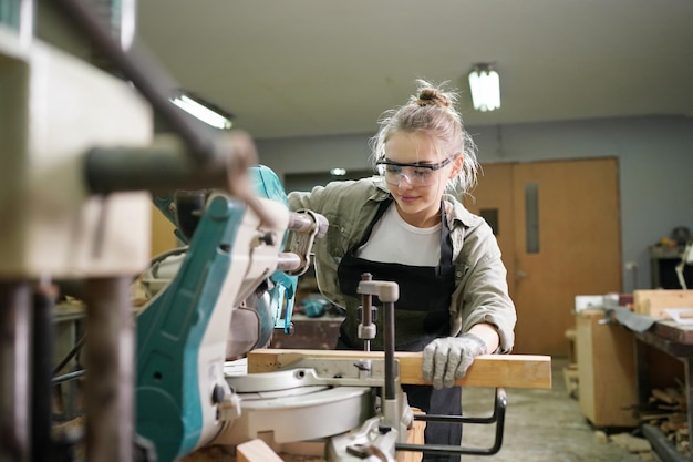 Piccola impresa di una giovane donna Attraente giovane donna falegname designer lavora in officina