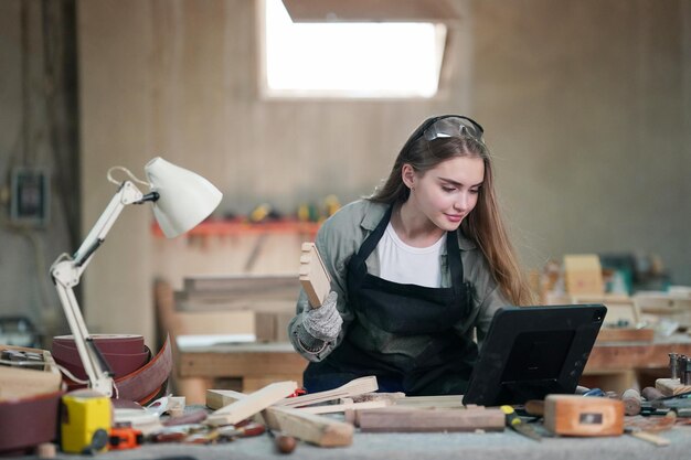 Piccola impresa di una giovane donna Attraente giovane donna falegname designer lavora in officina