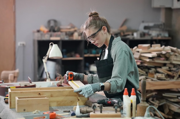 Piccola impresa di una giovane donna Attraente giovane donna falegname designer lavora in officina