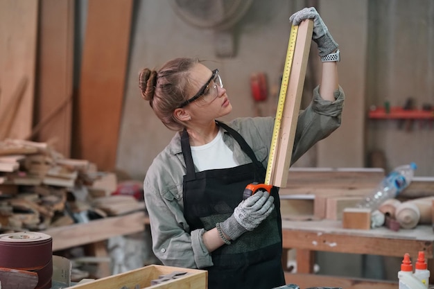 Piccola impresa di una giovane donna Attraente giovane donna falegname designer lavora in officina