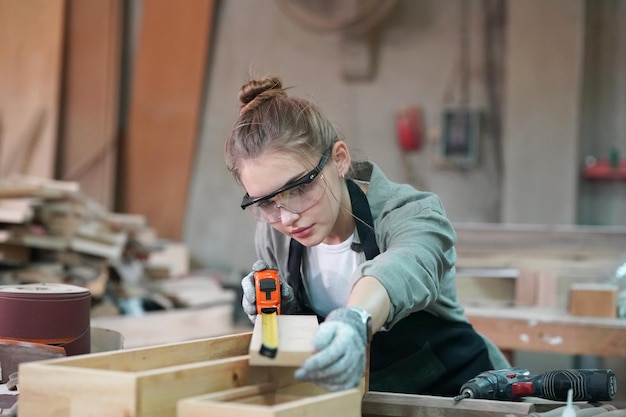 Piccola impresa di una giovane donna Attraente giovane donna falegname designer lavora in officina