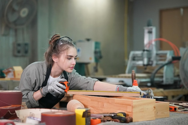 Piccola impresa di una giovane donna Attraente giovane donna falegname designer lavora in officina