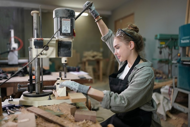 Piccola impresa di una giovane donna Bella giovane donna lavoratore in un laboratorio di mobili di misurazione del legno