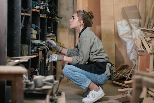 Piccola impresa di una giovane donna Bella giovane donna lavoratore in un laboratorio di mobili di misurazione del legno