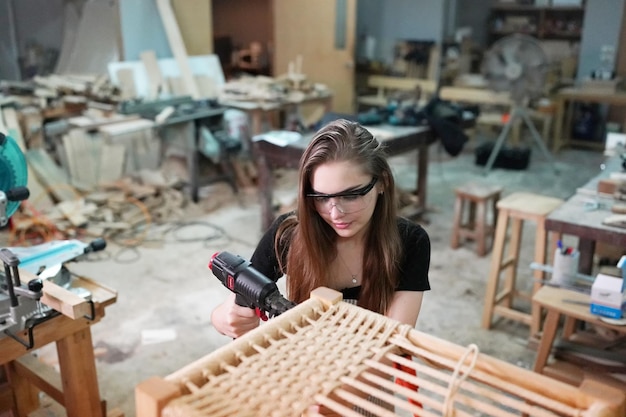 Piccola impresa di una giovane donna Bella giovane donna lavoratore in un laboratorio di mobili di misurazione del legno