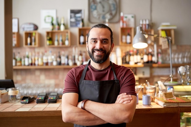 piccola impresa, persone e concetto di servizio: uomo felice o cameriere in grembiule al bar o alla caffetteria