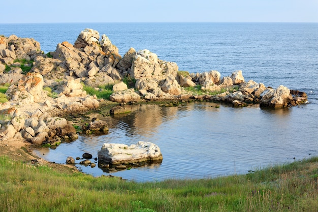 Piccola laguna di mare roccioso e erba costiera