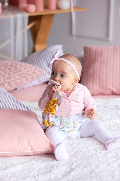 Piccola neonata divertente in interni moderni luminosi rosa.